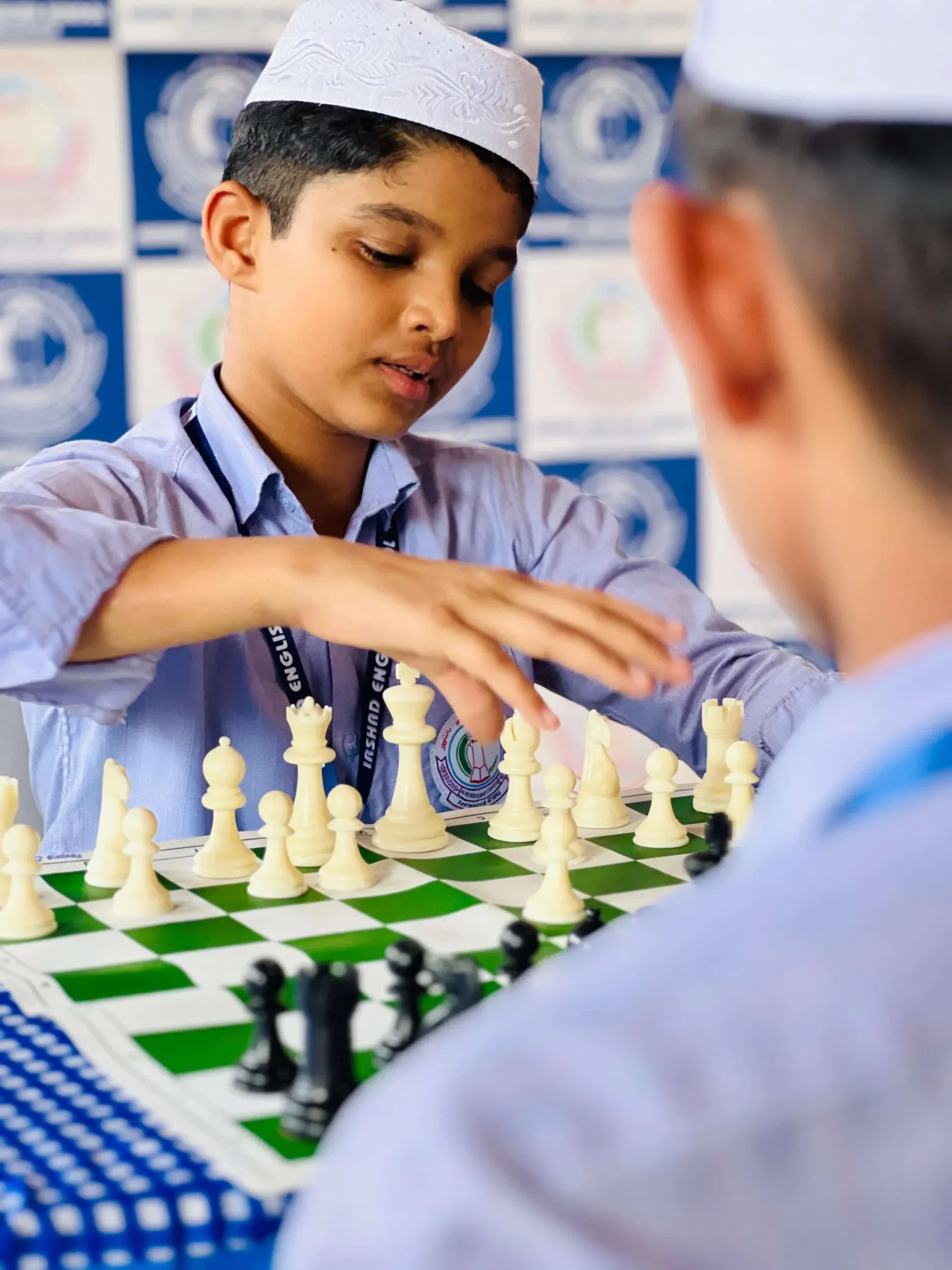 A student competing in a chess competition at Irshad English School