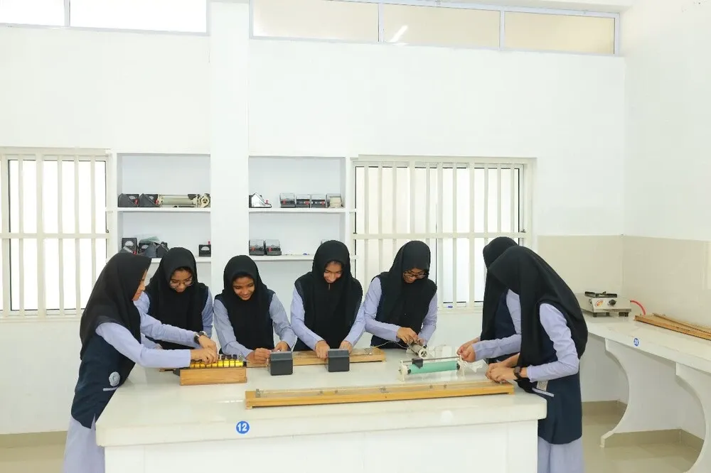 Students conducting experiments in the Irshad English School physics laboratory